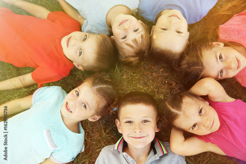 Playful children lying on grass Playful children lying on grass