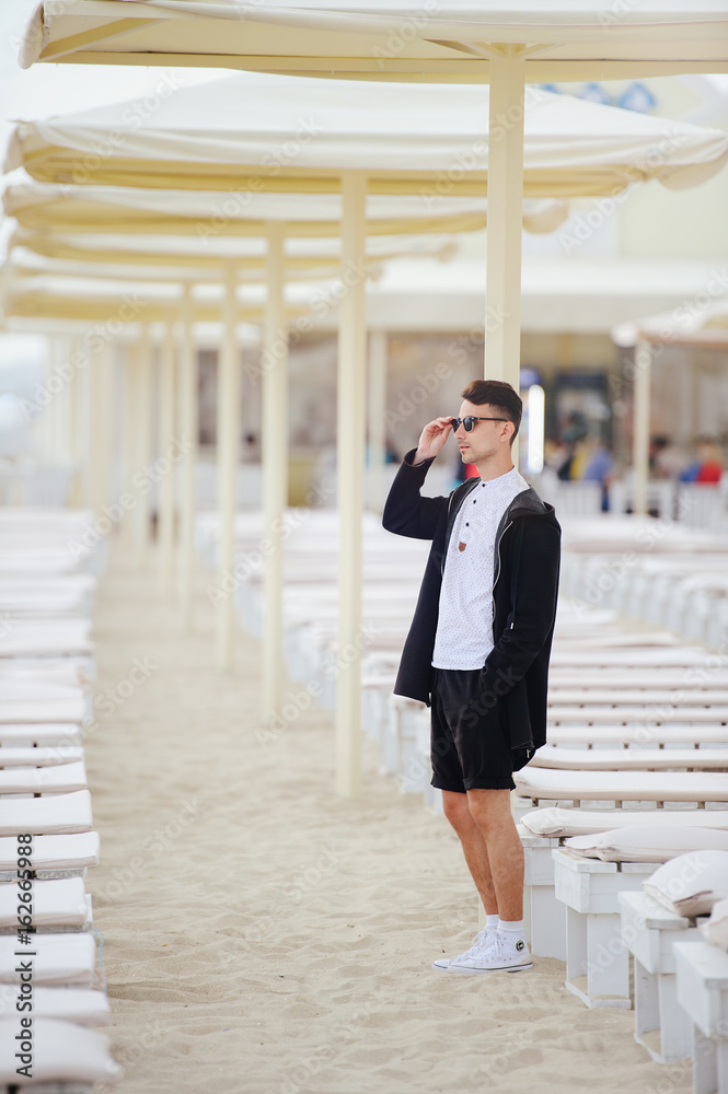 Young fashionable man on the beach, cool