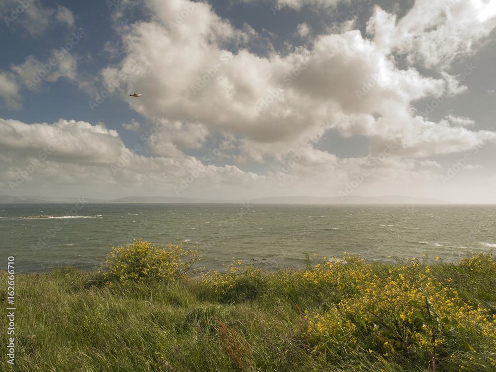 View on The Atlantic ocean from a cliff in Ireland on a cloudy day. View on The Atlantic ocean from a cliff in Ireland on a cloudy day.