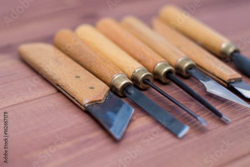 Tool kit for woodcarving. Knives for carving on wooden background