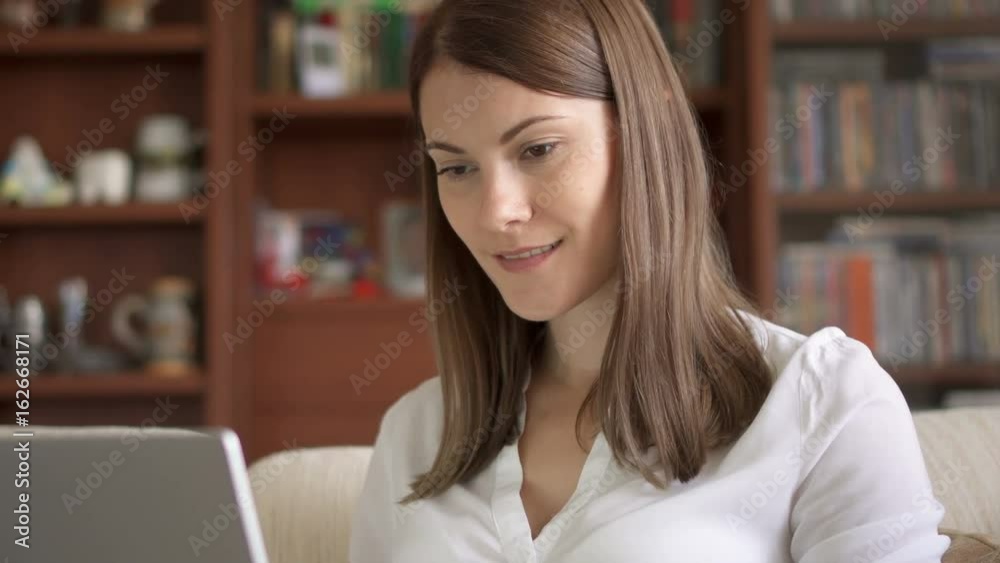 Attractive smiling professional woman working on laptop computer at home. Home-office concept Attractive smiling professional woman working on laptop computer at home. Home-office concept