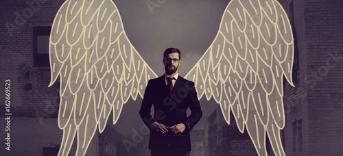 Φωτογραφία Business angel standing over apocalyptic background
