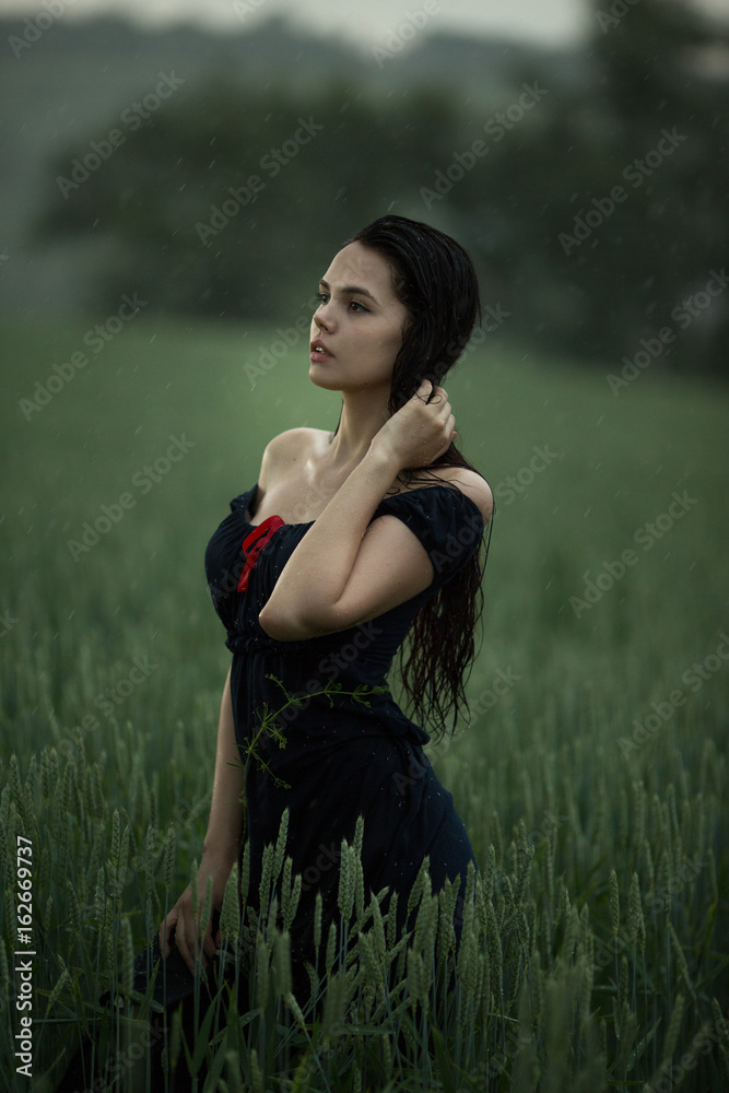 Natural female beauty in summer rain. Women enjoying nature in meadow.  Freedom concept background. Beautiful carefree woman in fields in rainy  weather. Stock Photo