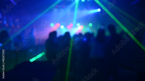   blurLight in club party Show And Silhouette hands of audience crowd people use smart phones enjoying the club party with concert. Blurry night club DJ party people enjoy of music dancing sound. photo
