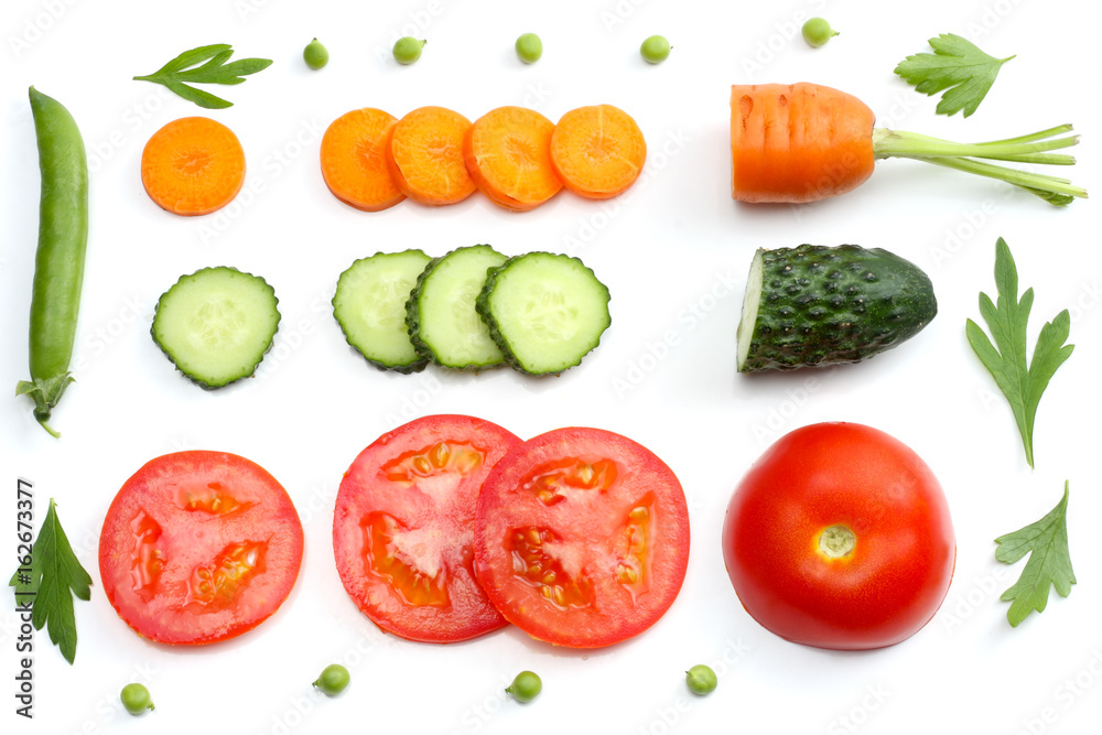 sliced tomatoes, sliced carrot, sliced cucumber, parsley and fresh green peas isolated on a white background. top view