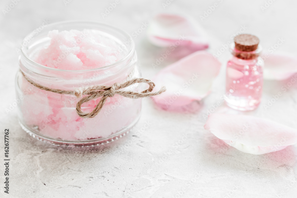 cosmetic set with rose blossom and body cream on white desk background
