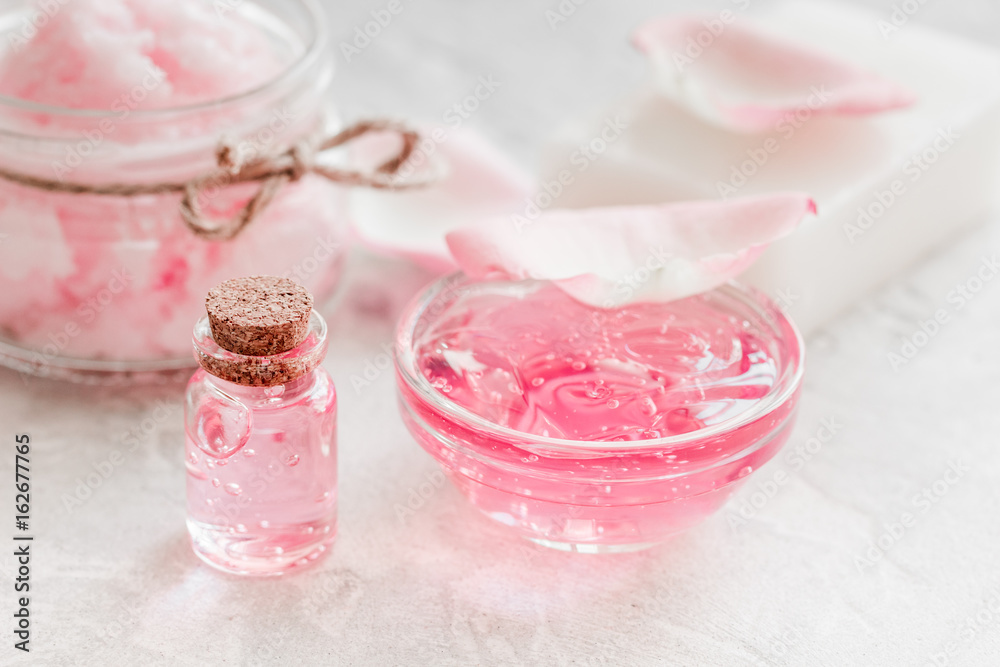 body treatment with rose petals and cosmetic set white desk background body treatment with rose petals and cosmetic set white desk background