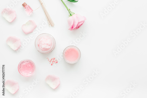 rose organic cosmetics with salt, cream and oil on white table background top view