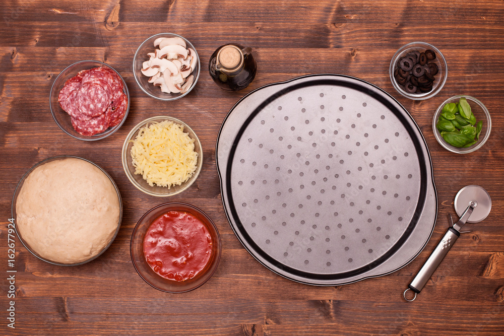 Pizza ingredients ready to be laid on the baking plate Pizza ingredients ready to be laid on the baking plate