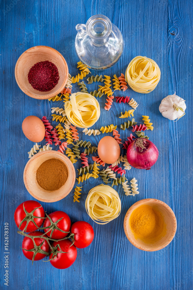 Food ingredients for Italian pasta on blue wooden desk background top view Food ingredients for Italian pasta on blue wooden desk background top view
