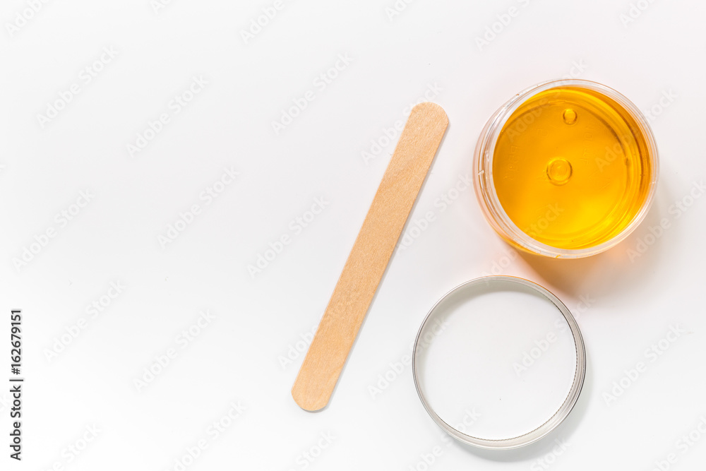 Wax and stick for depilation on white background top view copyspace Wax and stick for depilation on white background top view copyspace
