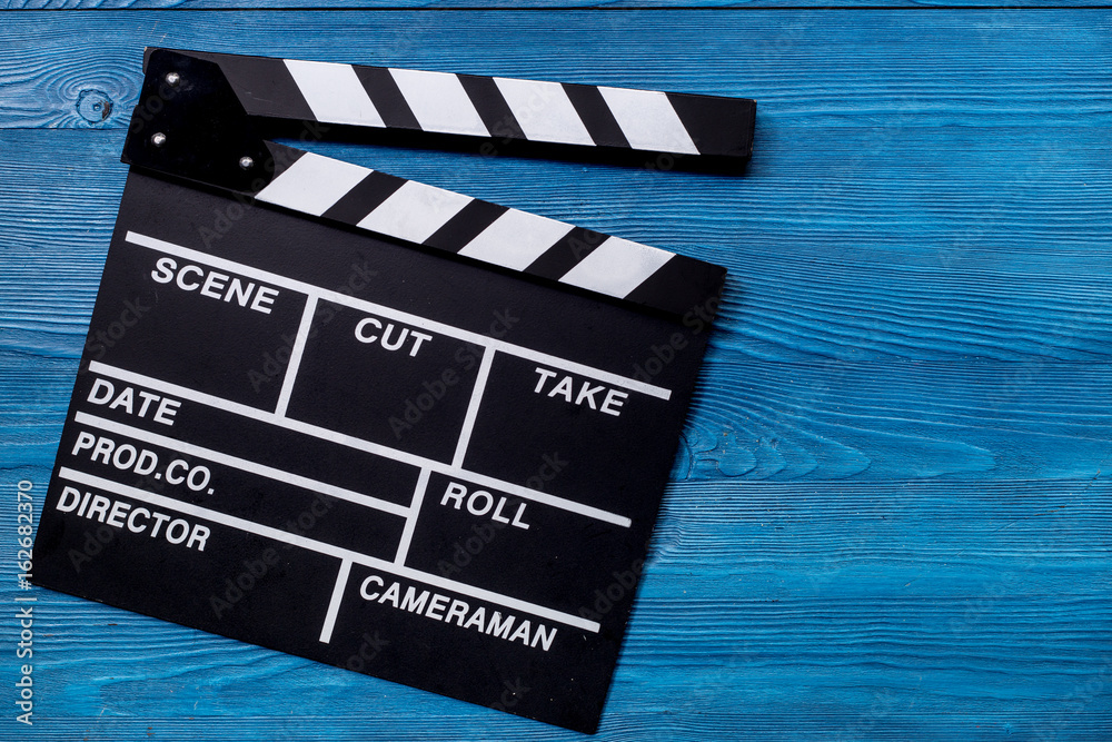 Movie clapperboard on wooden table background top view copyspace