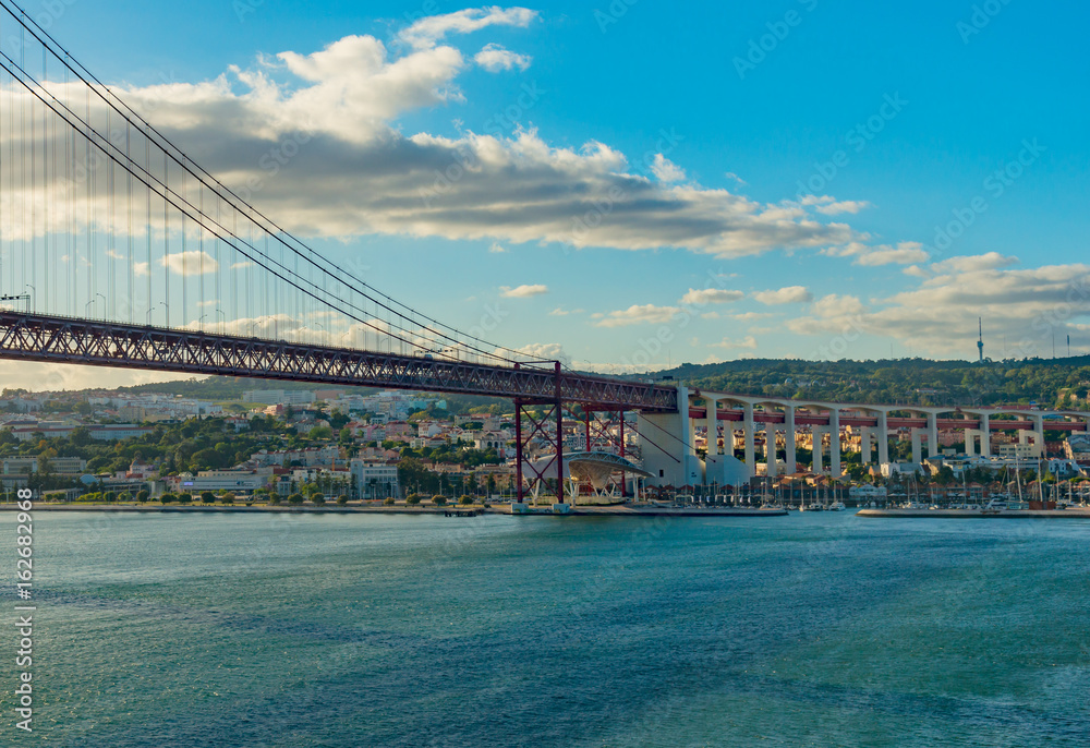 Fototapeta premium View of Lisbon, Portugal and the Abril 25 (April 25) suspension bridge in late afternoon light on a clear day