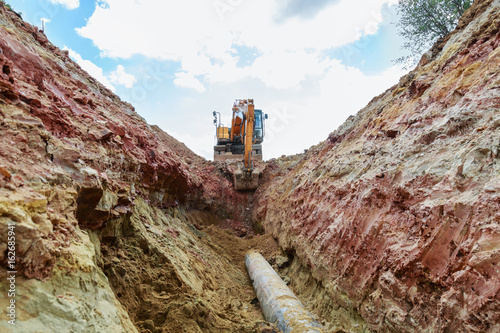 Excavator working on a construction site. Digging the trench for the pipeline. photo