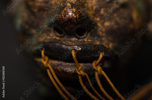Close up of the mouth of a shrunked human head from ecuador over a dark background photo