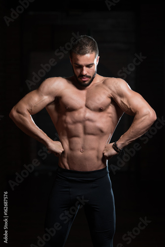 Muscular Model Flexing Back Muscles Pose