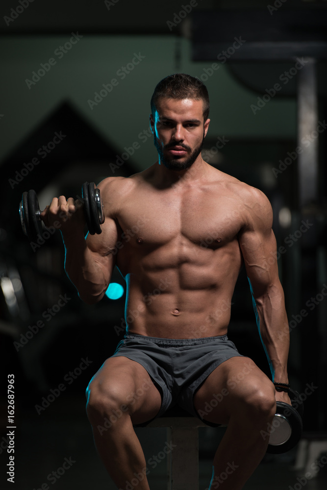 Athlete Exercising Biceps With Dumbbells