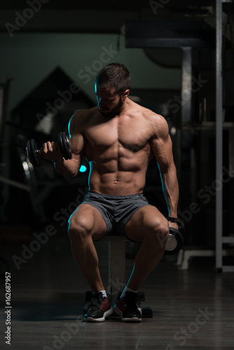 Biceps Exercise With Dumbbells In A Gym