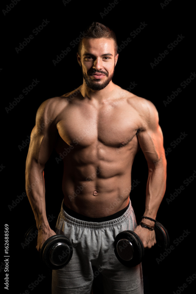 Man Exercise Biceps With Dumbbells On Black Background
