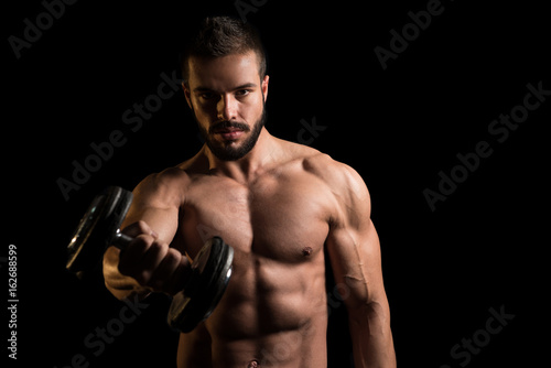 Athlete Working Out Shoulder On Black Background © Jale Ibrak