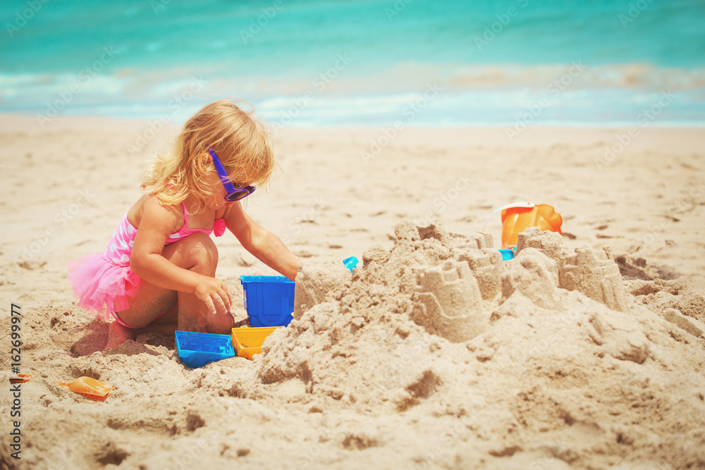 cute little girl play with sand on beach cute little girl play with sand on beach