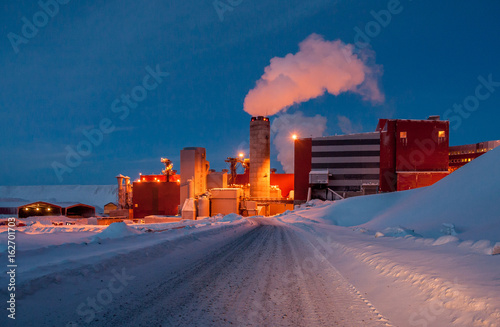 A manufacturing factory with smoking stalk. Iron ore mining industry beyond the polar circle, Kiruna, Sweden