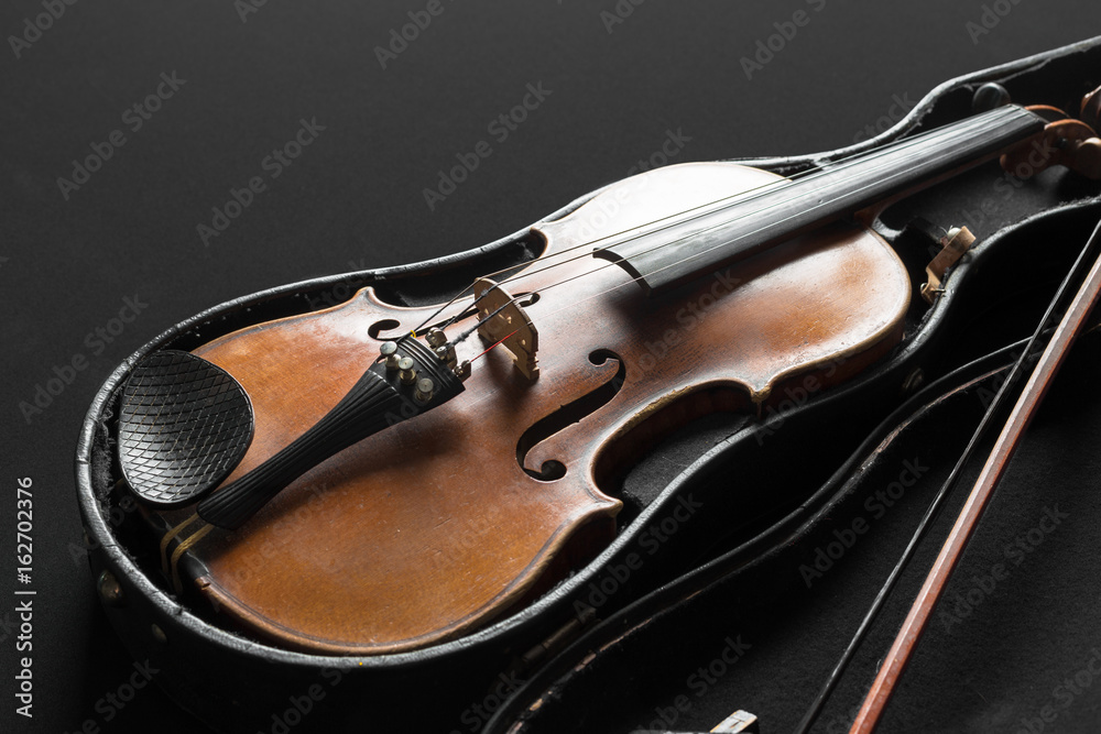Obraz premium Old violin on a black background