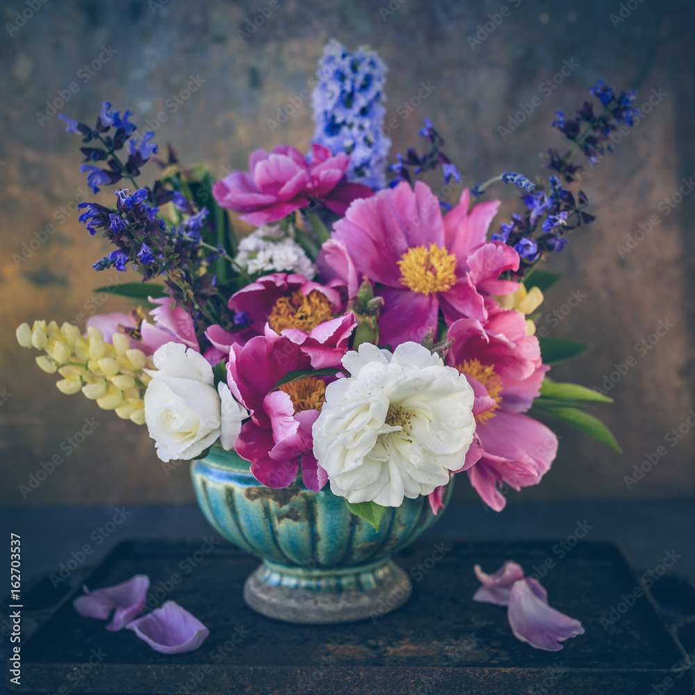 Beautiful still life bouquet of gardens flowers on a vintage background.