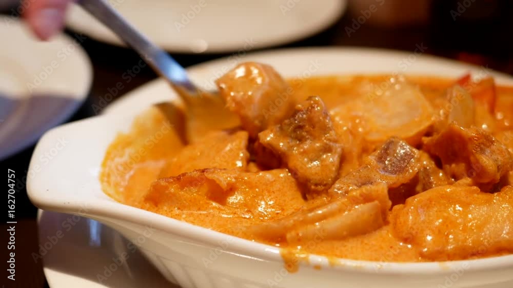 Motion of people stirring curry chicken by spoon on table inside Chinese restaurant Motion of people stirring curry chicken by spoon on table inside Chinese restaurant