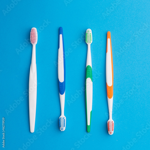 Multicolored toothbrushes on blue background