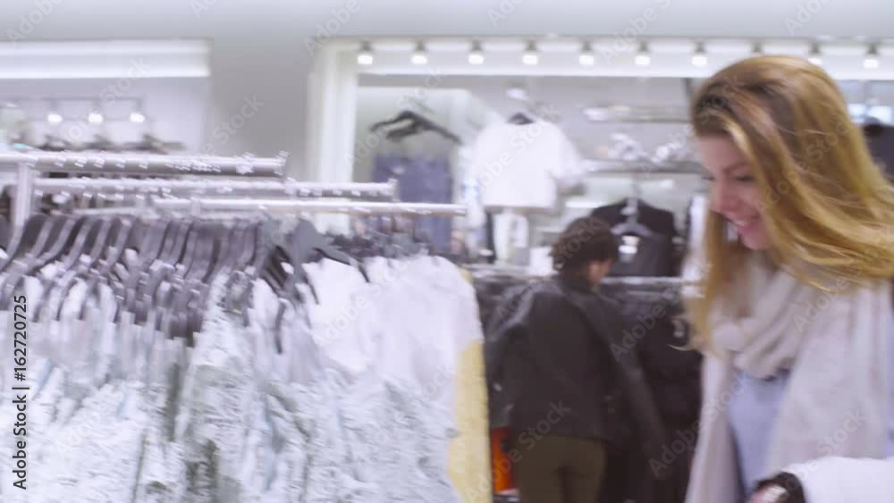 Young woman choosing dress in a clothing store Young woman choosing dress in a clothing store