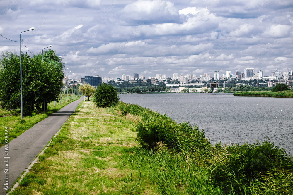 Picturesque asphalt road along the river with a view of the city Picturesque asphalt road along the river with a view of the city