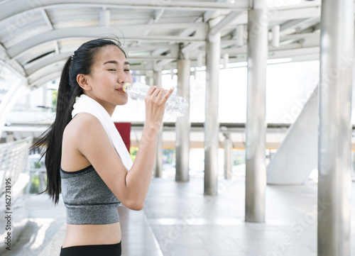 Free Download Asian woman in sport wear drinking water after running workout on city street, healthy and happy woman. - GFXLoad