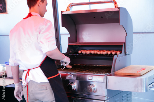 Grilling sausages on barbecue grill. BBQ in the garden. Bavarian sausages. photo