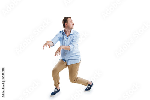 young scared man sneaking and looking away isolated on white