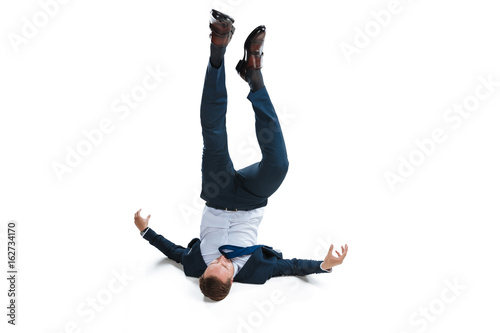 young businessman in suit falling upside down isolated on white