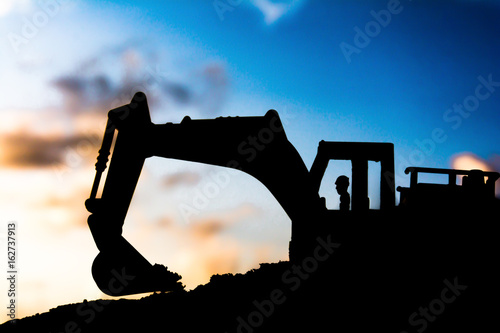 silhouette tracked excavator Sand and stone And sky background