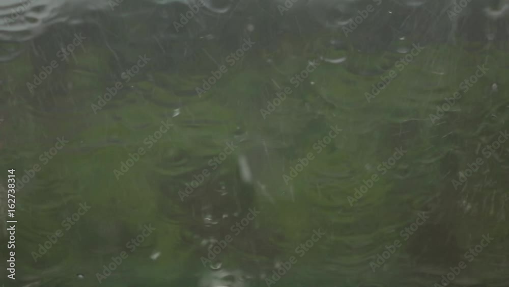 Raindrops on window glass flows in continuous streams. Slow motion Raindrops on window glass flows in continuous streams. Slow motion