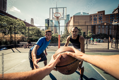Two street basketball players playing hard on the court photo