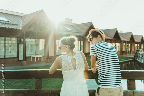 young casual couple standing together and looking away outdoors
