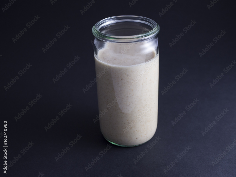 Fresh made sourdough starter in tall glass isolated on black background Fresh made sourdough starter in tall glass isolated on black background