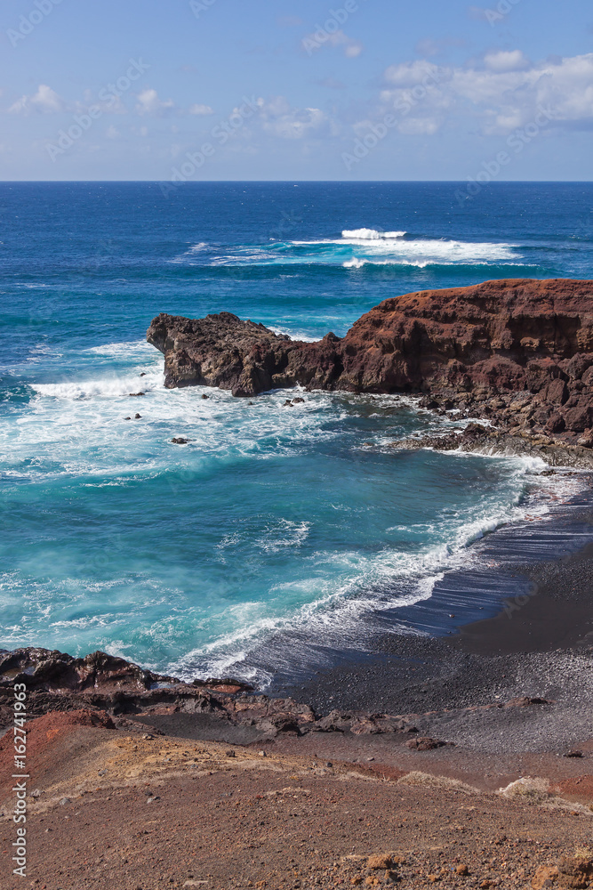 Black sandy beach in gulf El Golfo, shore of Atlantic ocean on Lanzarote island, Canary Islands, Spain Black sandy beach in gulf El Golfo, shore of Atlantic ocean on Lanzarote island, Canary Islands, Spain