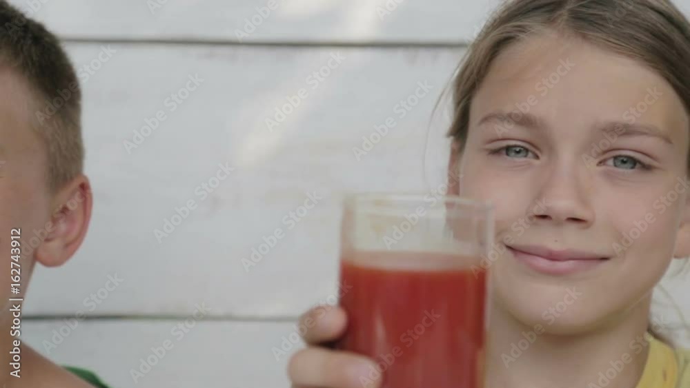 Boys drink orange and tomato juice. Children drink juice looking in a movie camera.
Boys drink orange and tomato juice. Children drink juice looking in a movie camera.
