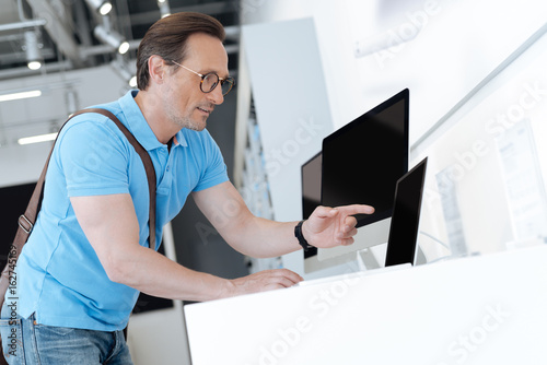 Amazed man fingering toward laptop at shop
