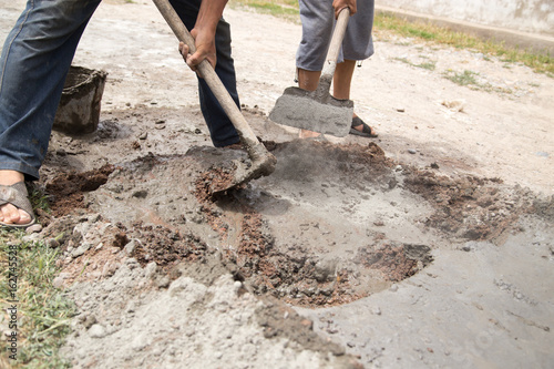 Worker stirs concrete shovel