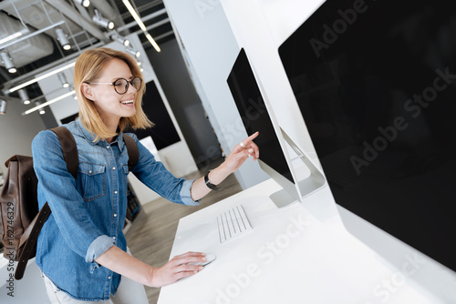 Very excited lady touching screen of personal computer at store photo