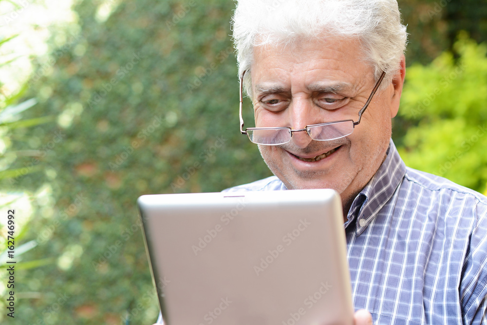 Old man using digital tablet. Old man using digital tablet.