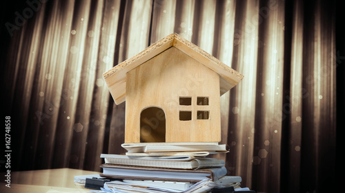 House and property for sale concept, wood house toy on office desk.
