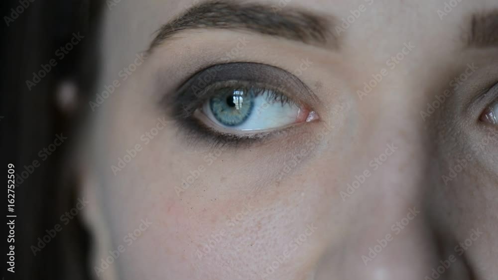 Make-up artist putting on make-up on model's eyes with cosmetic equipment. Eye mascara make-up.