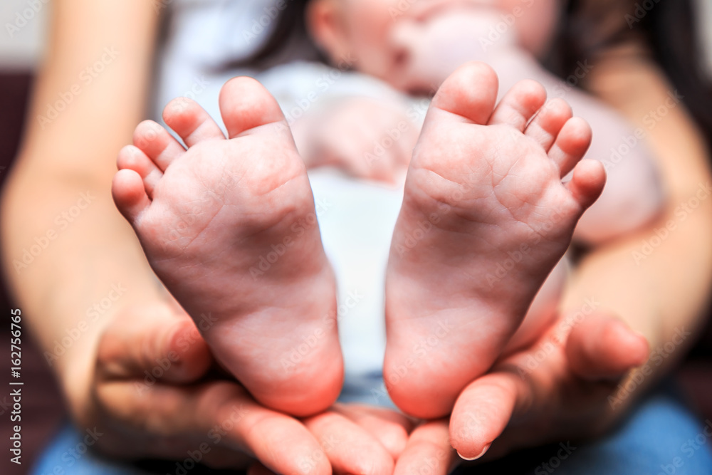 legs six-month baby in mother's arms legs six-month baby in mother's arms